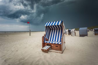 Düstere Gewitterwolken über dem Nordstrand von Norderney (Archivbild): Der deutsche Wetterdienst warnt vor Gewitter und schweren Sturmböen an der Nordsee.