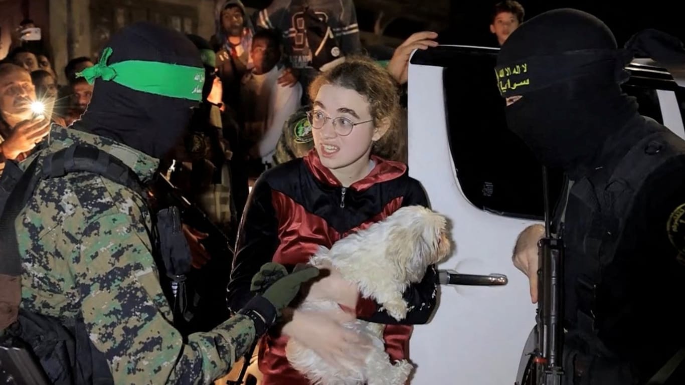 Eine der freigelassenen Geiseln zwischen zwei Terroristen der Hamas: Unter den Freigelassenen sollen zehn Israelis und zwei Ausländer sein.