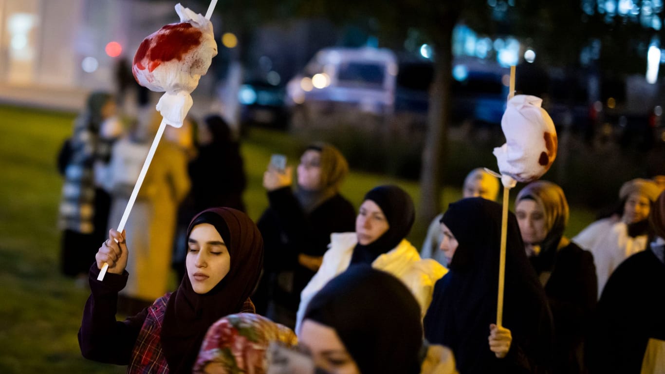 Frauen tragen bei der Demonstration kleine Bündel mit Kunstblut, die tote Kinder in Gaza symbolisieren sollen: Männer und Frauen mussten offenbar getrennt gehen.