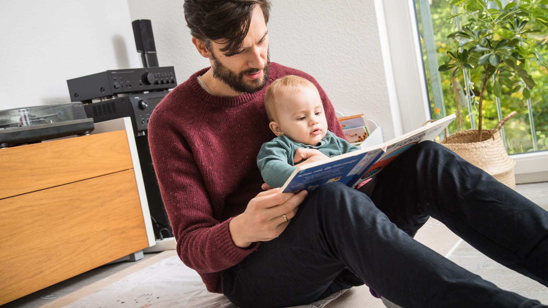 Vater liest seinem Kind vor: Elterngeld steht künftig weniger Familien zu.