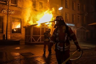 Einsatzkräfte der Feuerwehr vor der brennenden Hütte: Das Feuer auf dem Flensburger Weihnachtsmarkt konnte schnell gelöscht werden.