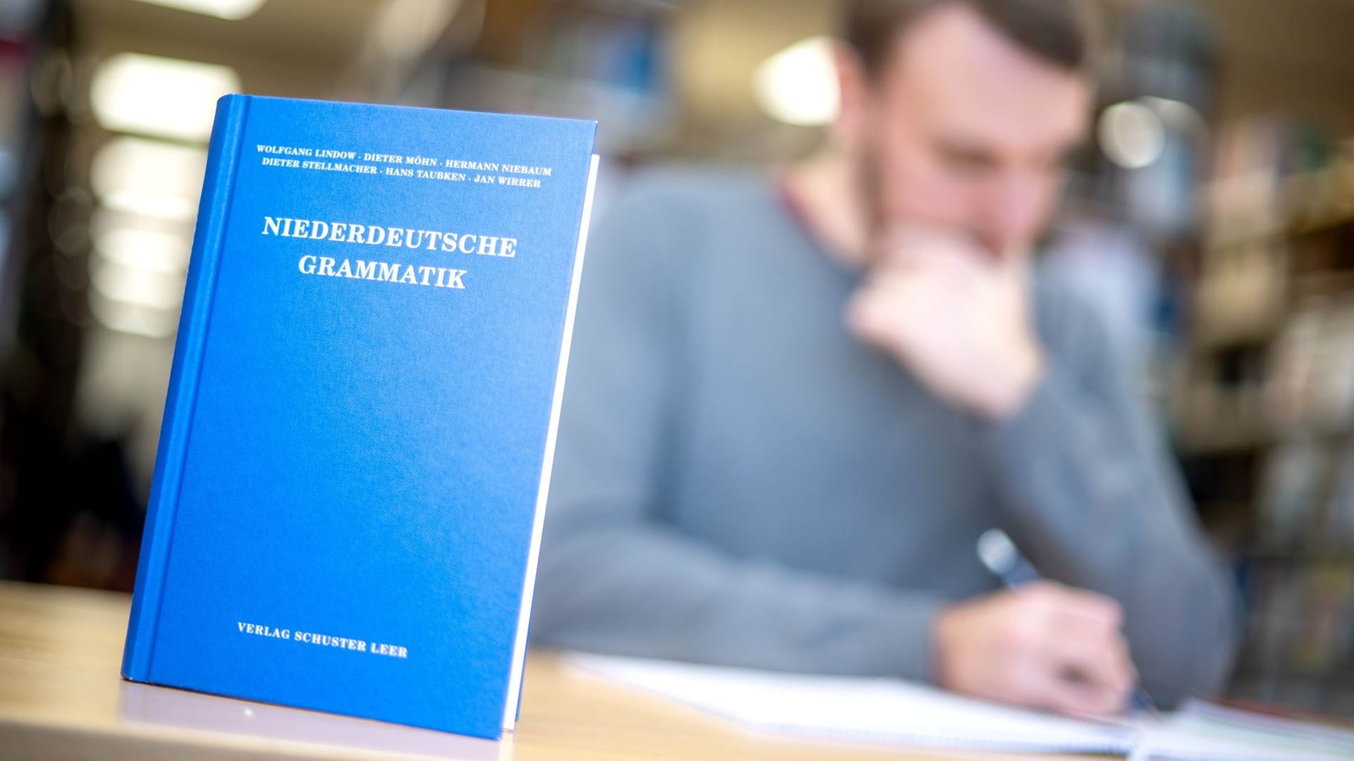 Ein Lehrbuch für die Niederdeutsche Grammatik steht in der Bibliothek der Carl von Ossietzky Universität in Oldenburg, im Hintergrund lernt der Student André Graën.