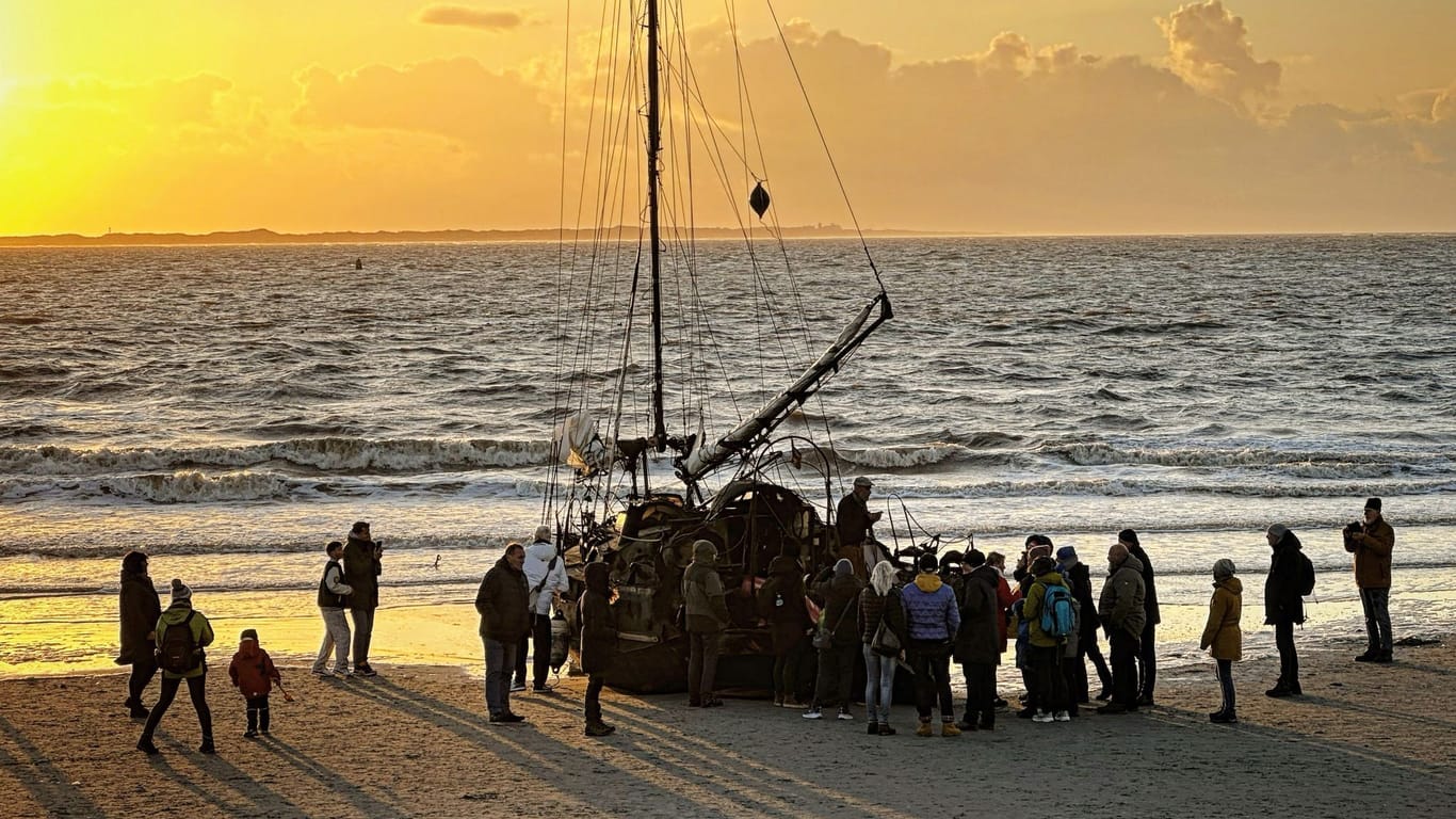 Ein am Weststrand von Norderney gestrandetes Segelschiff mit Schaulustigen. Der Besitzer des Schiffs dürfte noch einige Tage am Strand der Insel wohnen.