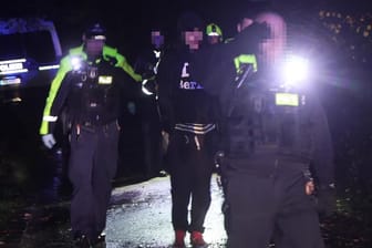 Ein Tatverdächtiger wird abgeführt: Er soll einen Mann im Plänterwald getötet haben.