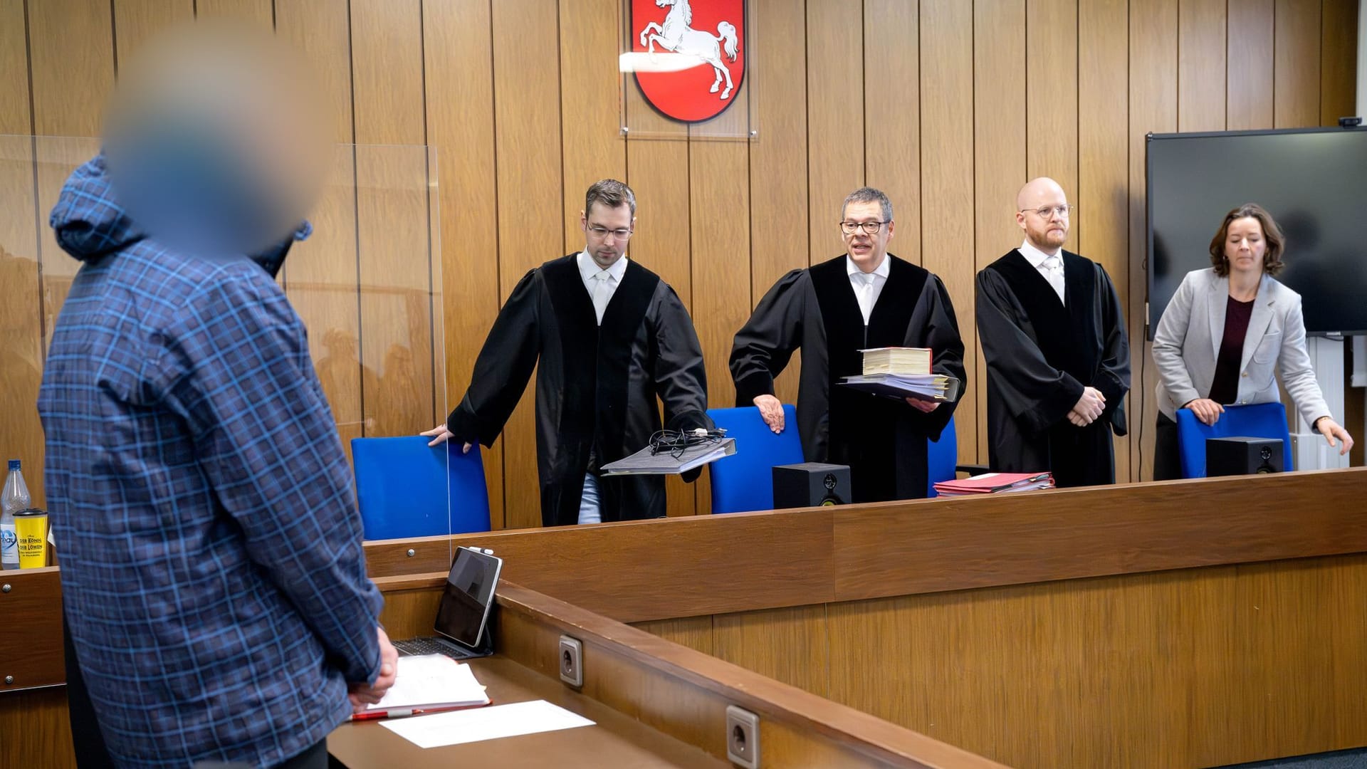 Der Angeklagte (l) steht vor Prozessbeginn vor dem Vorsitzenden Richter Volker Stronczyk (3.v.r.). Der Angeklagte (l) steht vor Prozessbeginn vor dem Vorsitzenden Richter Volker Stronczyk (3.v.r.).