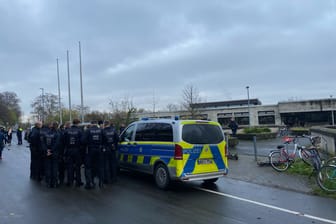 Köln-Müngersdorf: Einsatzkräfte und ein Polizeiwagen stehen vor dem Schulkomplex.