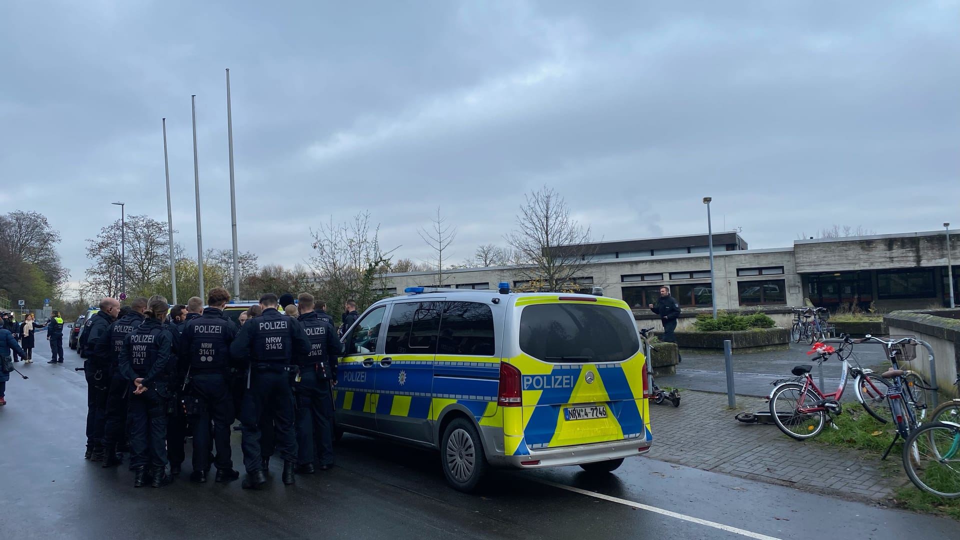 Köln-Müngersdorf: Einsatzkräfte und ein Polizeiwagen stehen vor dem Schulkomplex. Köln-Müngersdorf: Einsatzkräfte und ein Polizeiwagen stehen vor dem Schulkomplex.