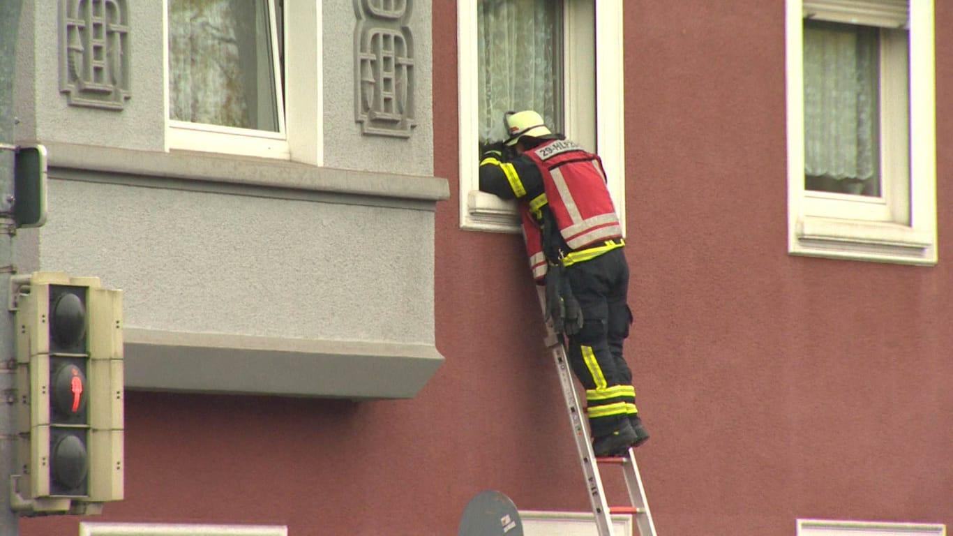 Ein Feuerwehrmann auf der Leiter eines Mehrfamilienhauses an der Schützenstraße: Eine Seniorin musste ins Krankenhaus gebracht werden.