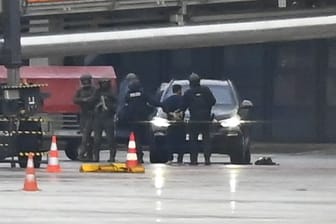 Hamburg: Der Geiselnehmer wird auf dem Flughafen von der Polizei weggeführt. Ein bewaffneter Mann hatte auf dem Airport seine vierjährige Tochter in seiner Gewalt gehalten.