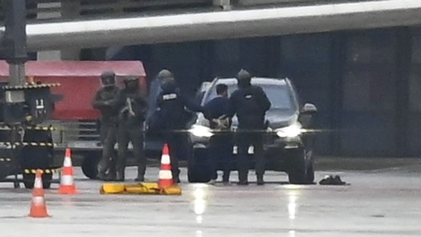 Hamburg: Der Geiselnehmer wird auf dem Flughafen von der Polizei weggeführt. Ein bewaffneter Mann hatte auf dem Airport seine vierjährige Tochter in seiner Gewalt gehalten.