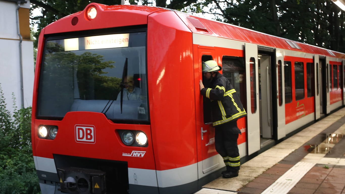 Ein Mitglied der Feuerwehr an einer S-Bahn (Archivbild): Bei Hamburg kam es zu einem Unfall.