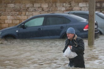 Ein Mann läuft durch eine überflutete Straße auf der Krim. Mehre Hunderttausend Menschen auf der Krim haben keinen Strom.