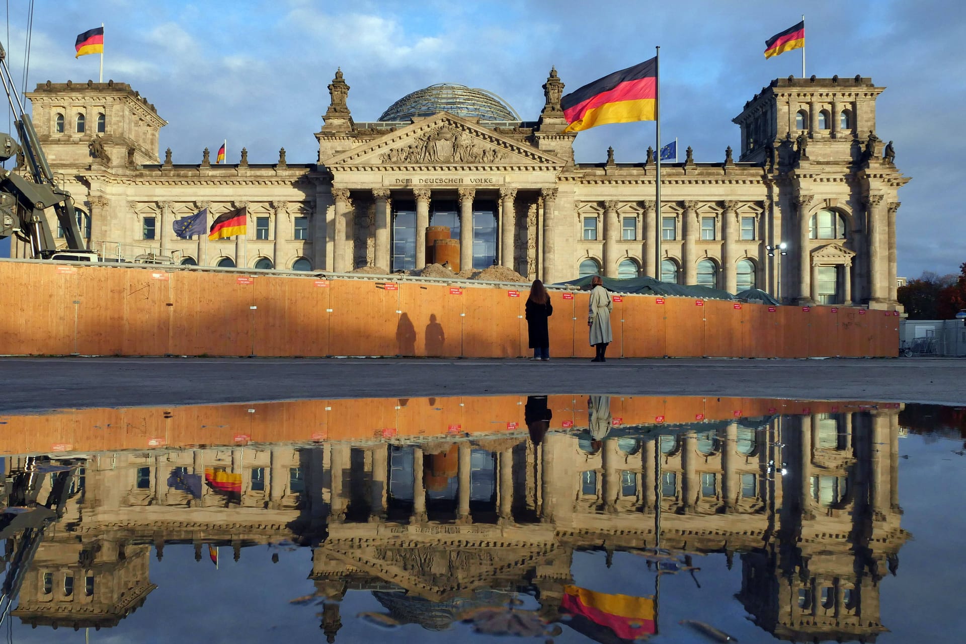 Der Reichstag spiegelt sich in einer Pfütze nach einem Regenguss (Archivbild): Auch in der neuen Wolke bleibt es in Berlin und Brandenburg überwiegend feucht.