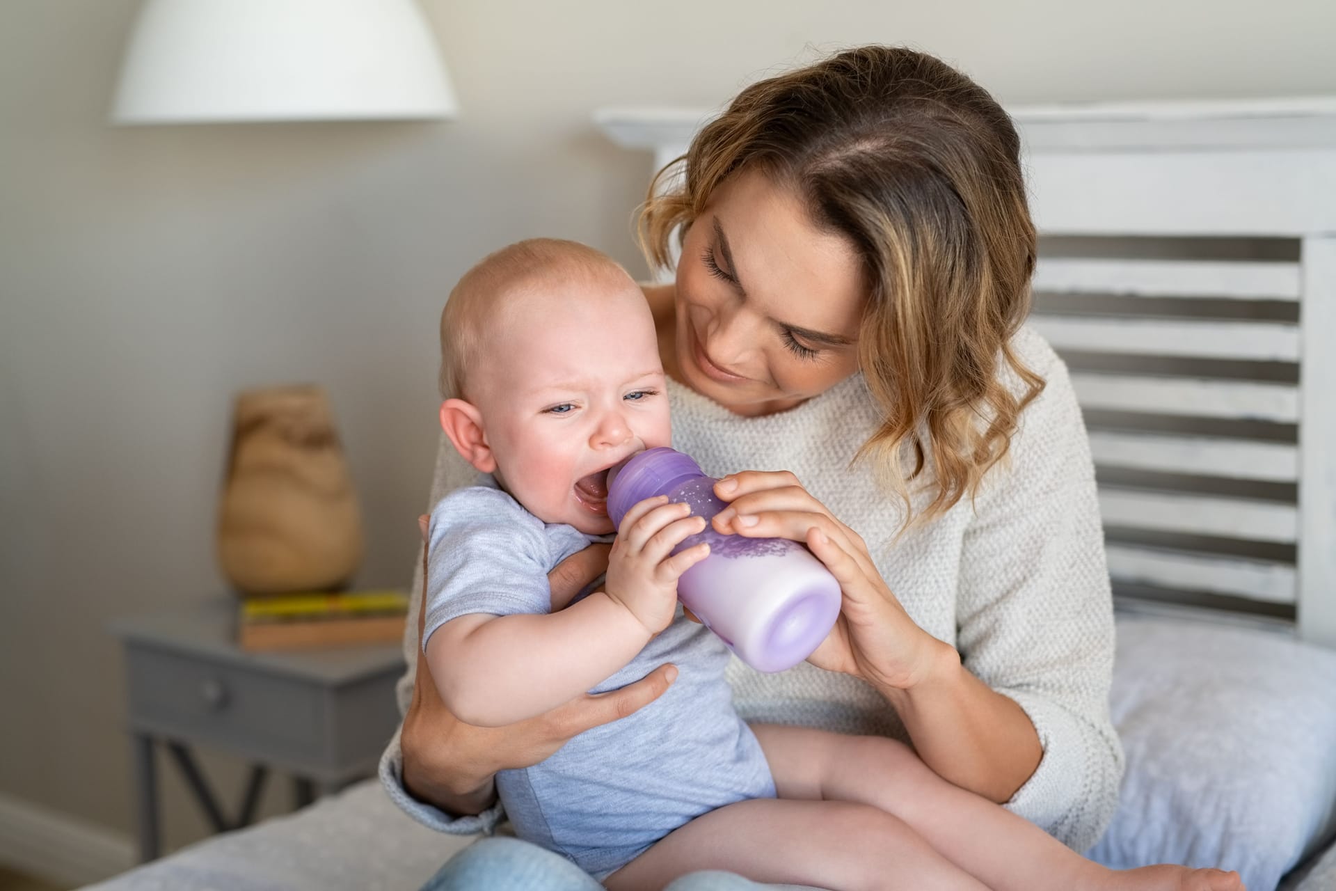 Ein Baby wird mit einer Flasche gefüttert und weint.