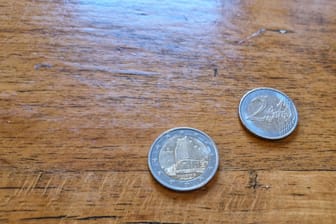 Auf einem Tisch liegen 2-Euro-Münzen .