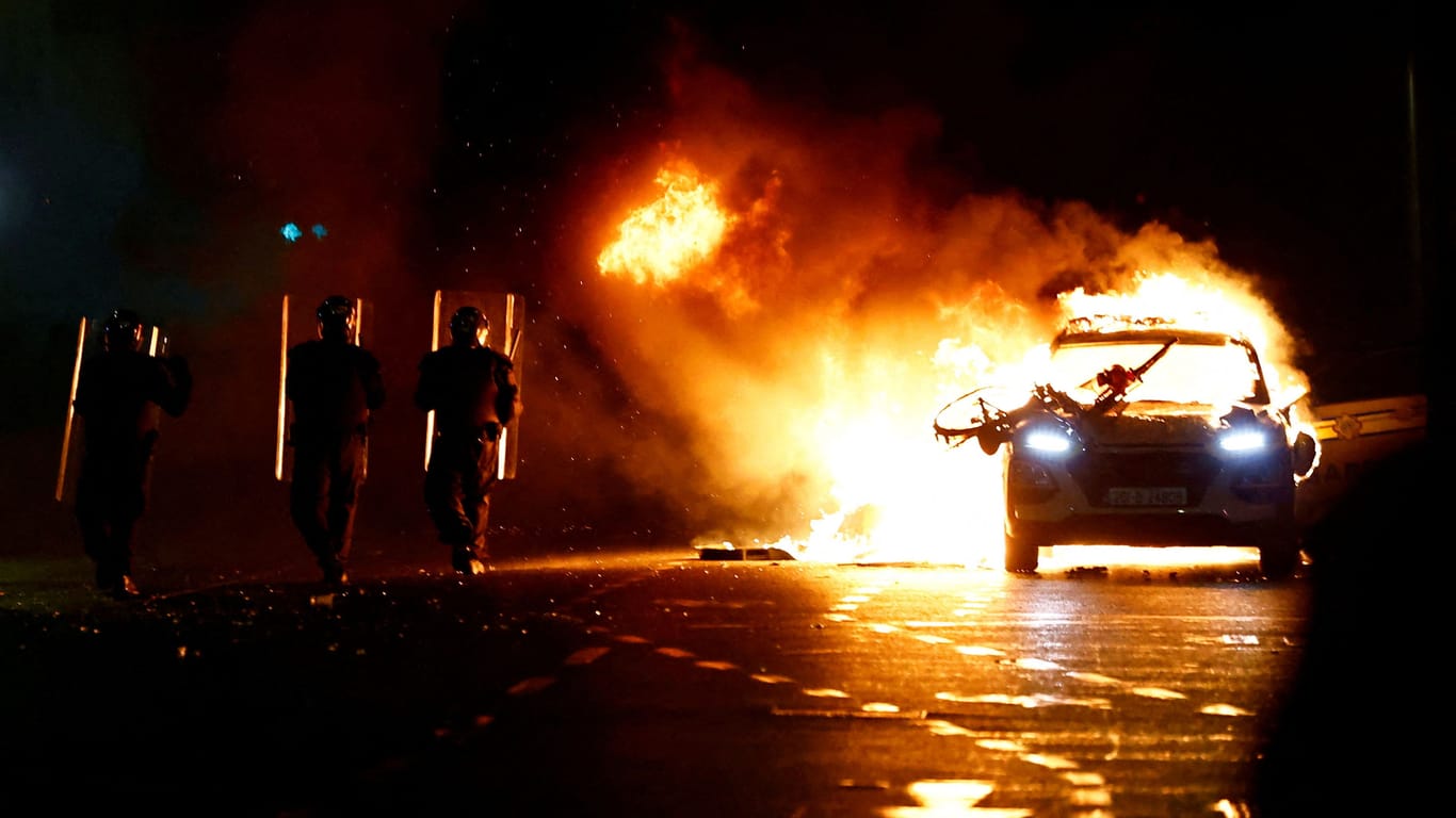 Ein Auto brennt in Dublin: Nach einem Messerangriff auf Kinder entlädt sich die Wut einiger Menschen auf den Straßen.