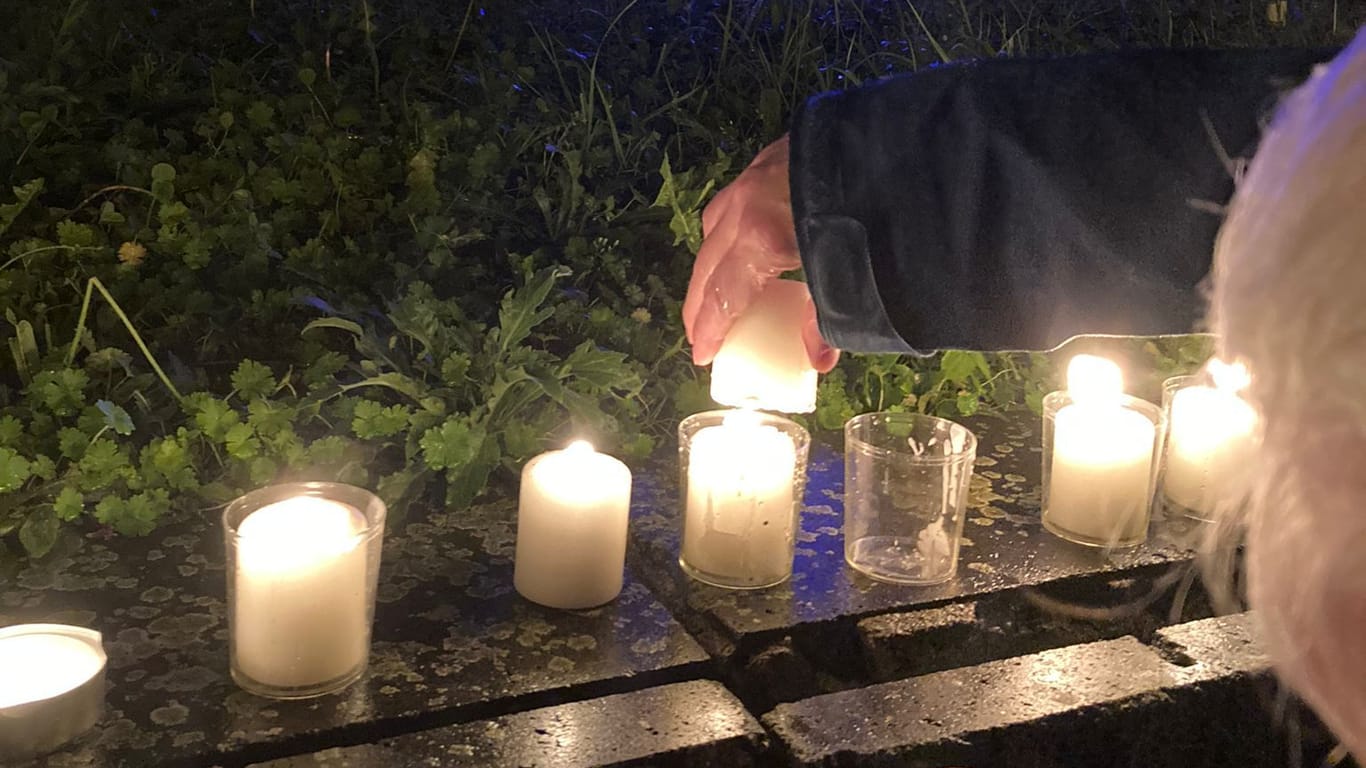 Zum Gedenken: Eine Teilnehmerin entzündet Kerzen vor der Kölner Synagoge.