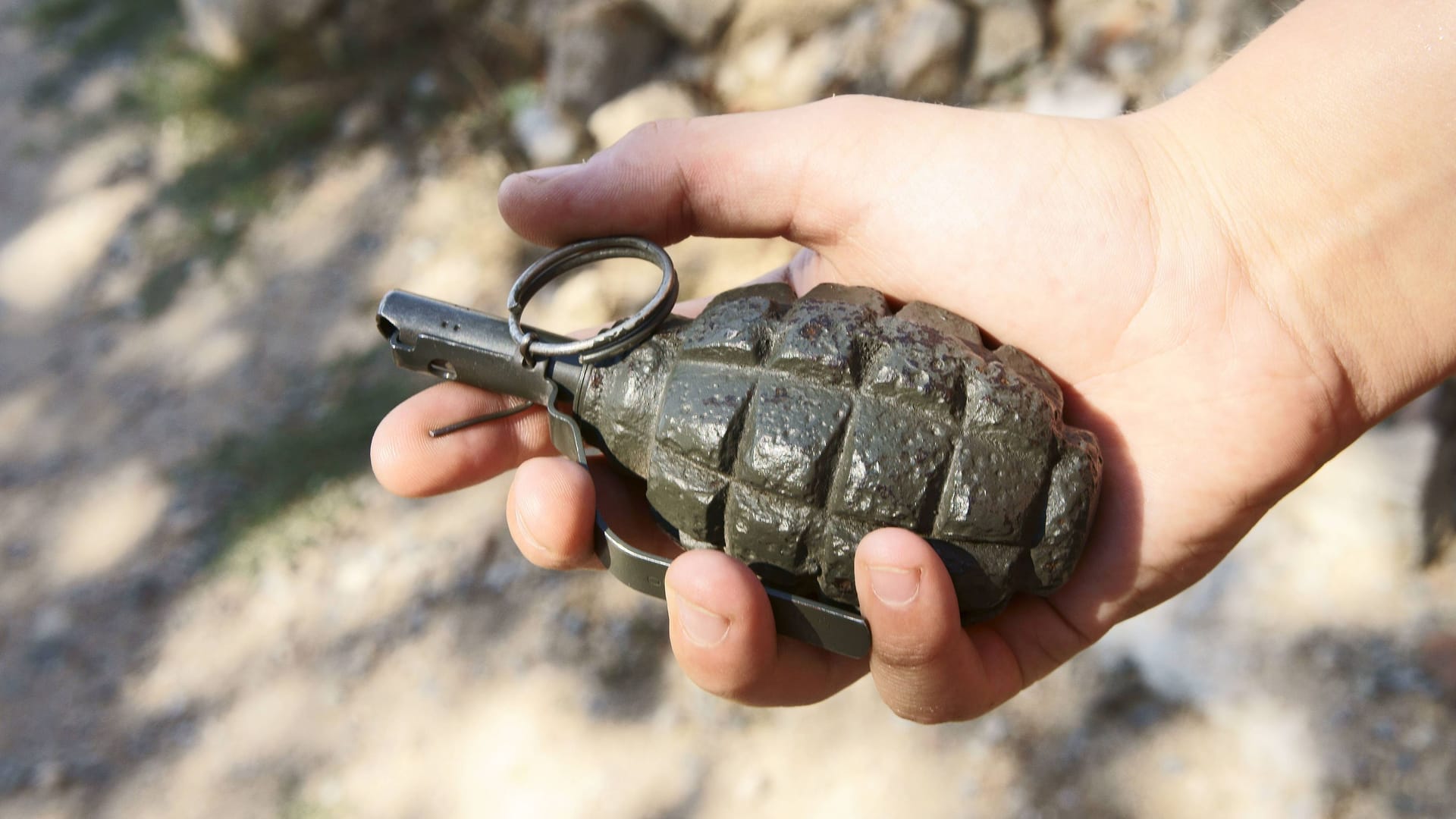 Mann hält eine Handgranate (Symbolfoto): In Berlin ist nun ein Mann wegen versuchten Mordes mit der Kriegswaffe verurteilt worden. Mann hält eine Handgranate (Symbolfoto): In Berlin ist nun ein Mann wegen versuchten Mordes mit der Kriegswaffe verurteilt worden.