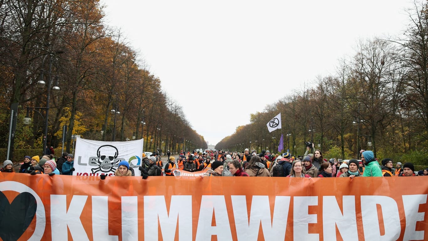 Personen halten Banner hoch: Wieder kommt es einer großen Blockade von Berlins wohl bekanntester Straße.