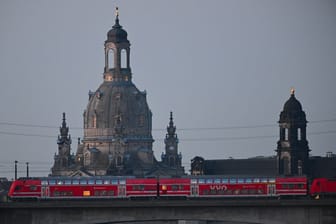 Eine S-Bahn des VVO fährt vor der Altstadt mit der Frauenkirche