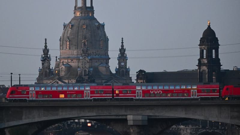 Eine S-Bahn des VVO fährt vor der Altstadt mit der Frauenkirche