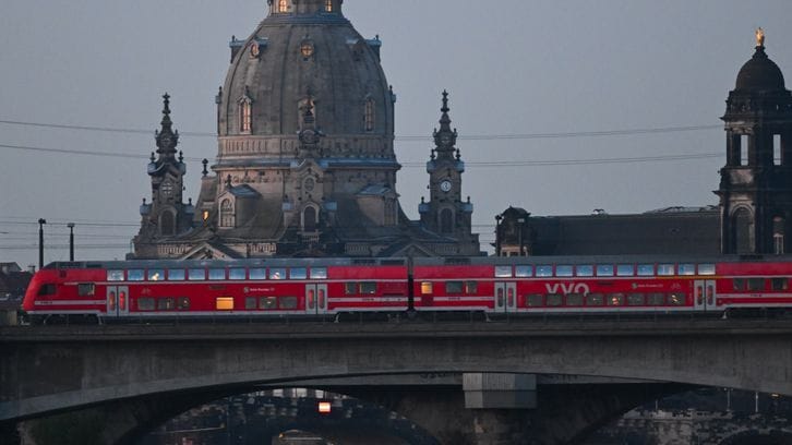 Eine S-Bahn des VVO fährt vor der Altstadt mit der Frauenkirche