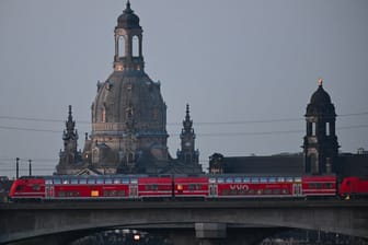 Eine S-Bahn des VVO fährt vor der Altstadt mit der Frauenkirche