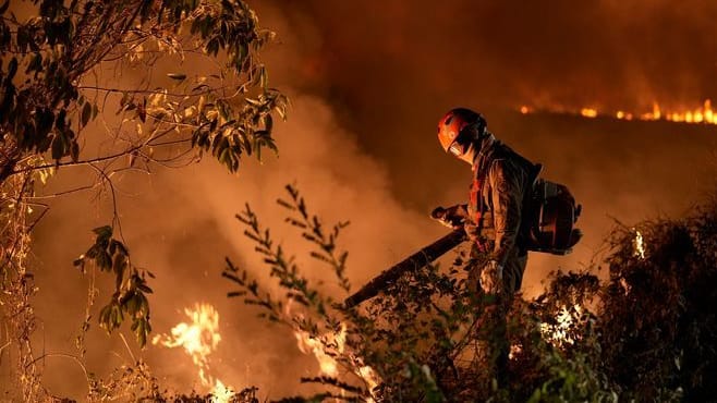 Feuerwehrmann steht inmitten eines Waldbrandes: Brasilien wird derzeit von einer Hitzewelle heimgesucht.