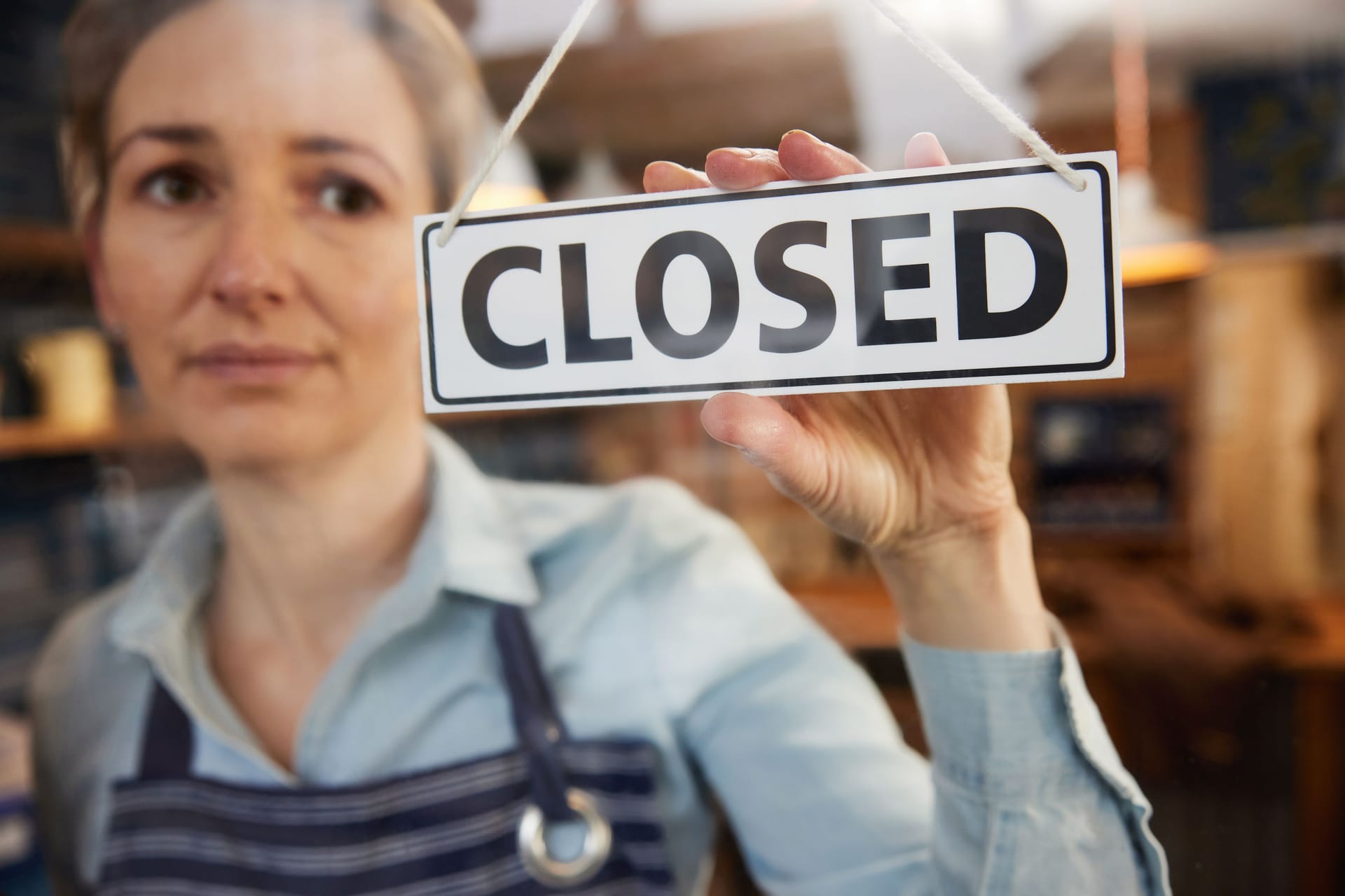 Eine Frau schließt ein Restaurant (Symbolbild): Sollte die Mehrwertsteuer auf Speisen wieder erhöht werden, könnte laut des Metzgers ein Gastrosterben drohen.