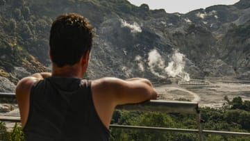 Ein Tourist blickt auf den Krater des Solfatare: Der Solfatare gehört zu den vierzig Vulkanen der Phlegräischen Felder in Italien.