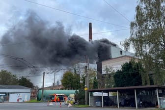 Eine dichte Rauchsäule stand am Samstag über Solingen: Einsatzkräfte der Feuerwehr löschten den Brand eines Müllheizkraftwerks später auch von einer Drehleiter aus.