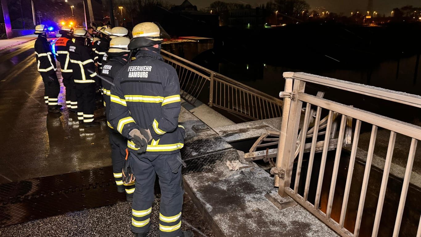 Einsatzkräfte stehen vor der eingedrückten Brücke: Passanten fürchteten, ein Fahrzeug könnte ins Wasser gestürzt sein.