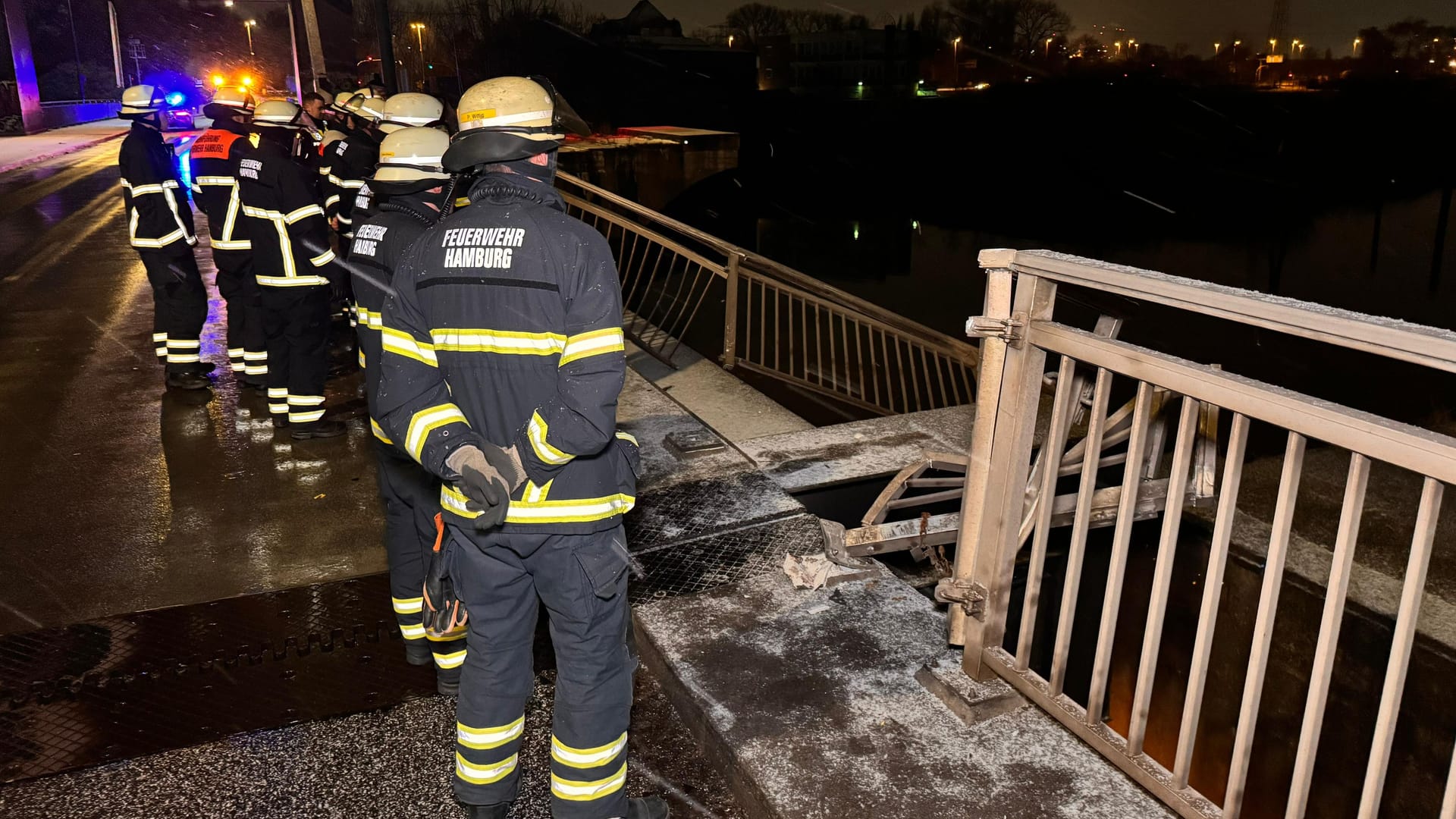 Einsatzkräfte stehen vor der eingedrückten Brücke: Passanten fürchteten, ein Fahrzeug könnte ins Wasser gestürzt sein.