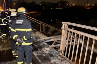 Einsatzkräfte stehen vor der eingedrückten Brücke: Passanten fürchteten, ein Fahrzeug könnte ins Wasser gestürzt sein.