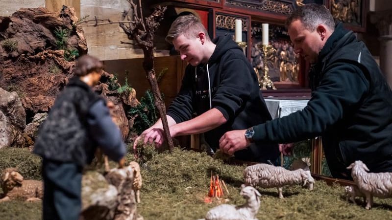 Marco Saffer (links) und Mesner Sebastian Dornheim (rechts) legen den Boden der Krippe mit Moos aus.