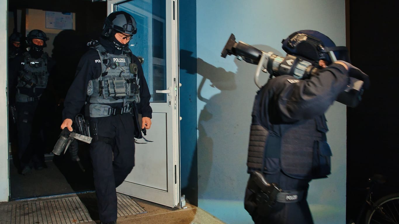Spezialkräfte verlassen bei einer Razzia der Bundespolizei und Landespolizei Brandenburg ein Haus: Insgesamt nahm die Polizei drei Personen fest.