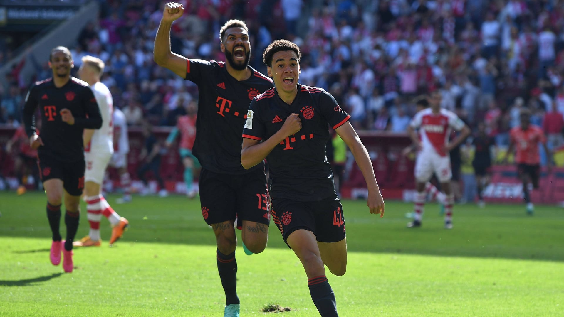 Jamal Musiala und Eric Maxim Choupo-Moting rennen zu den Fans: Ein emotionaler Triumph für die Bayern.