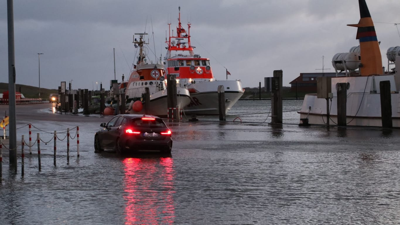 Ein Auto steht in einem bei einer Sturmflut überspülten Hafenbereich auf der ostfriesischen Insel Norderney.