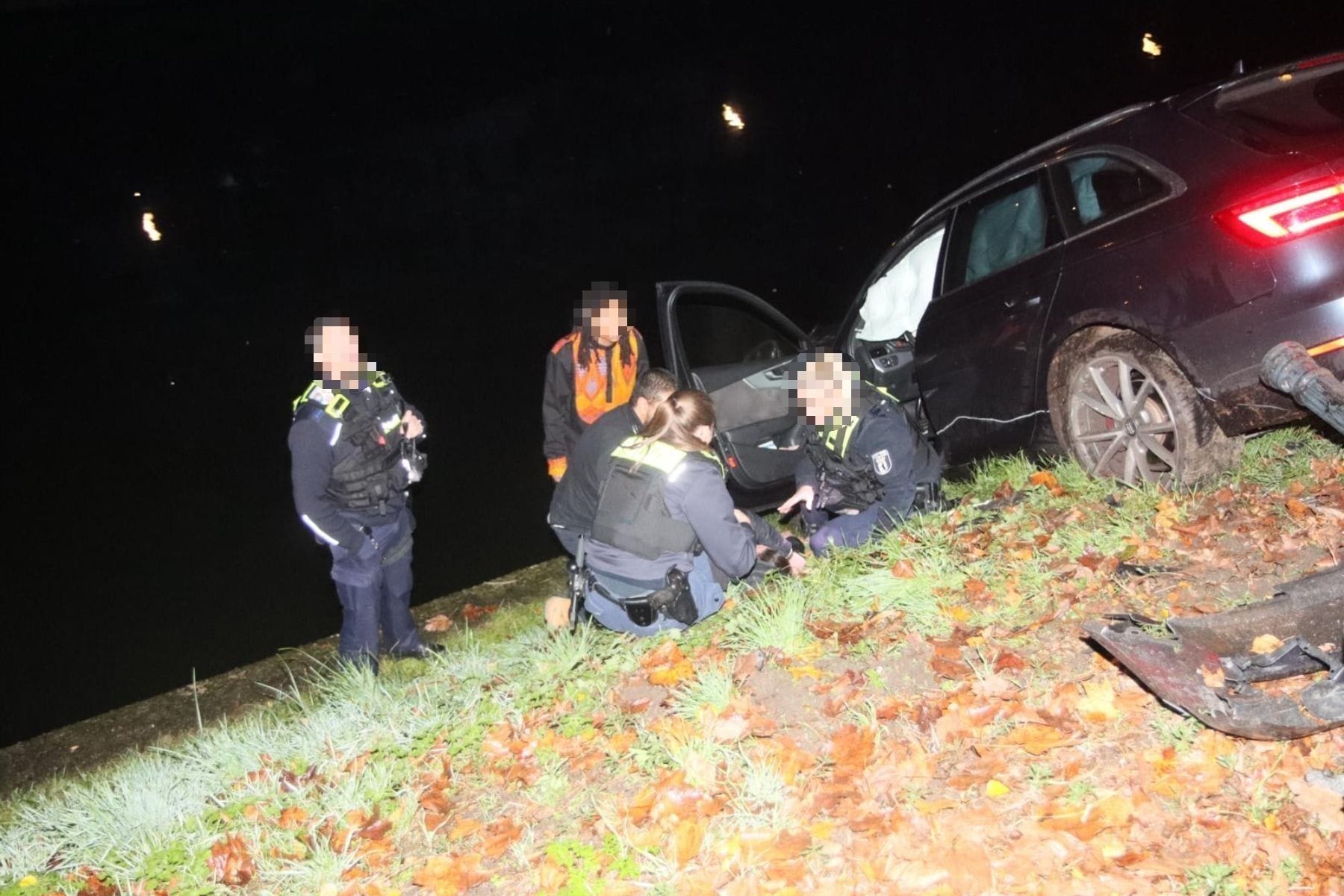 Polizeikräfte in der Nähe vom verletzten Fahrer: Sie versuchen, ihn zu beruhigen.