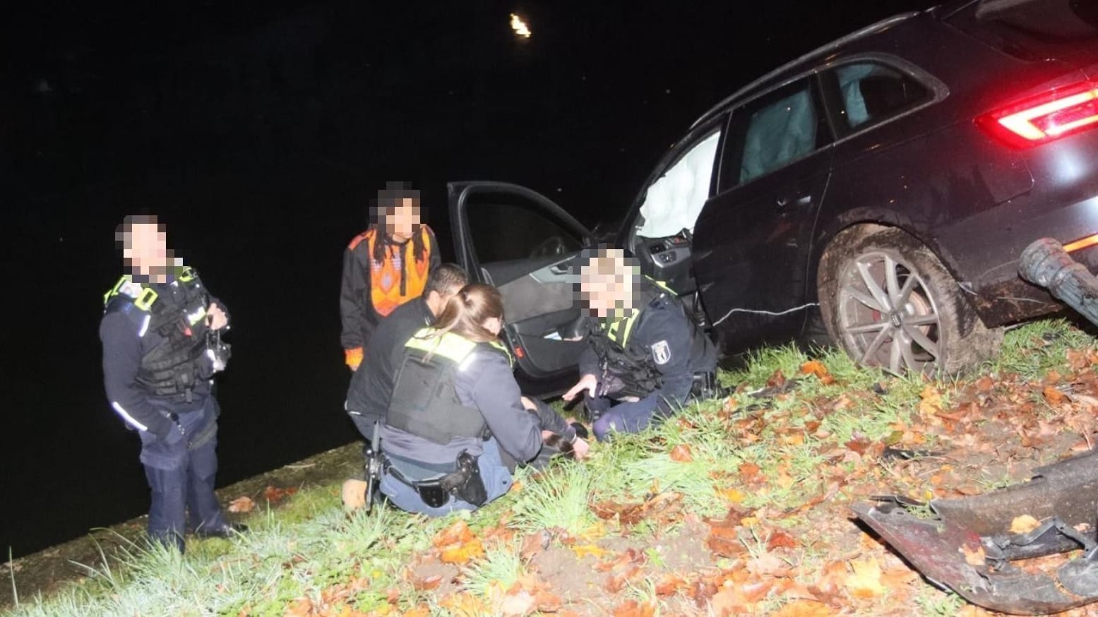 Polizeikräfte in der Nähe vom verletzten Fahrer: Sie versuchen, ihn zu beruhigen.