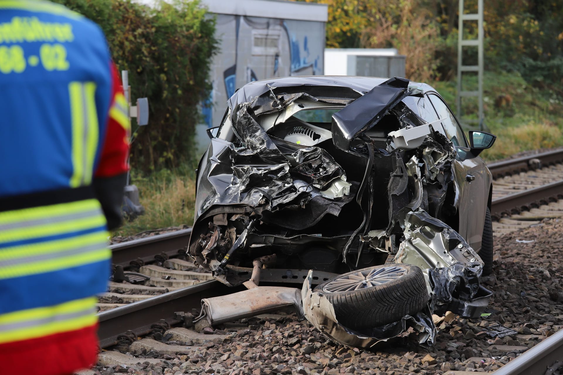 Der völlig zerstörte Pkw steht auf Zuggleisen: Der Fahrer konnte sich rechtzeitig in Sicherheit bringen.