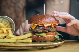Cheeseburger: Für eine Scheibe Käse auf dem Hamburger müssen Verbraucher oft tief in die Tasche greifen.