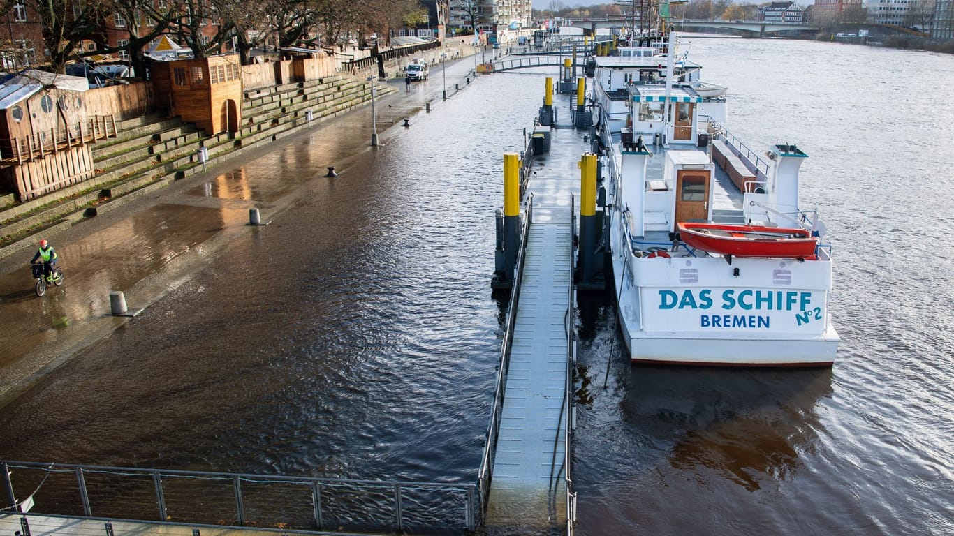 Ein Steg zu einem Schiff in der Weser steht unter Wasser.