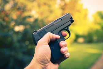 Ein Mann hält eine Pistole in der Hand (Symbolbild): Bei den gefundenen Waffen handelt es sich um Softair- und Schreckschusswaffen.