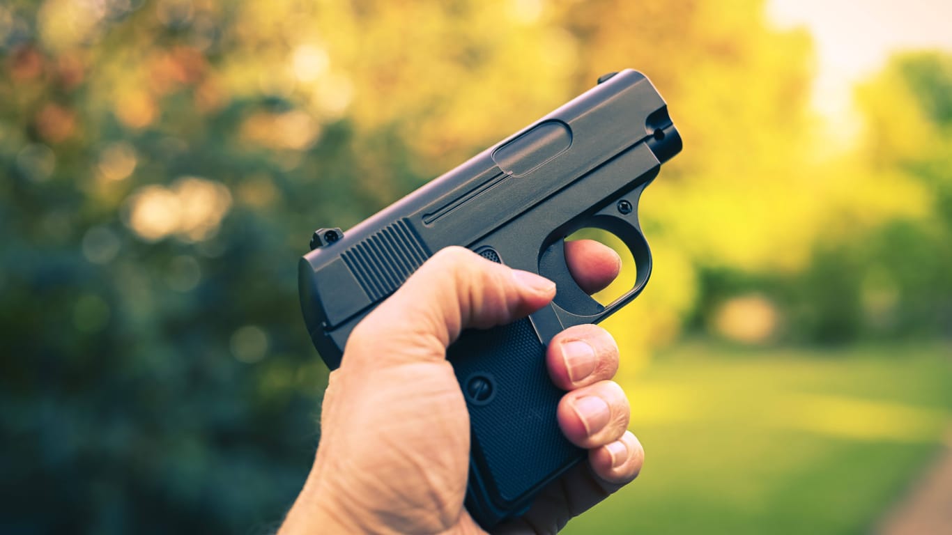 Ein Mann hält eine Pistole in der Hand (Symbolbild): Bei den gefundenen Waffen handelt es sich um Softair- und Schreckschusswaffen.