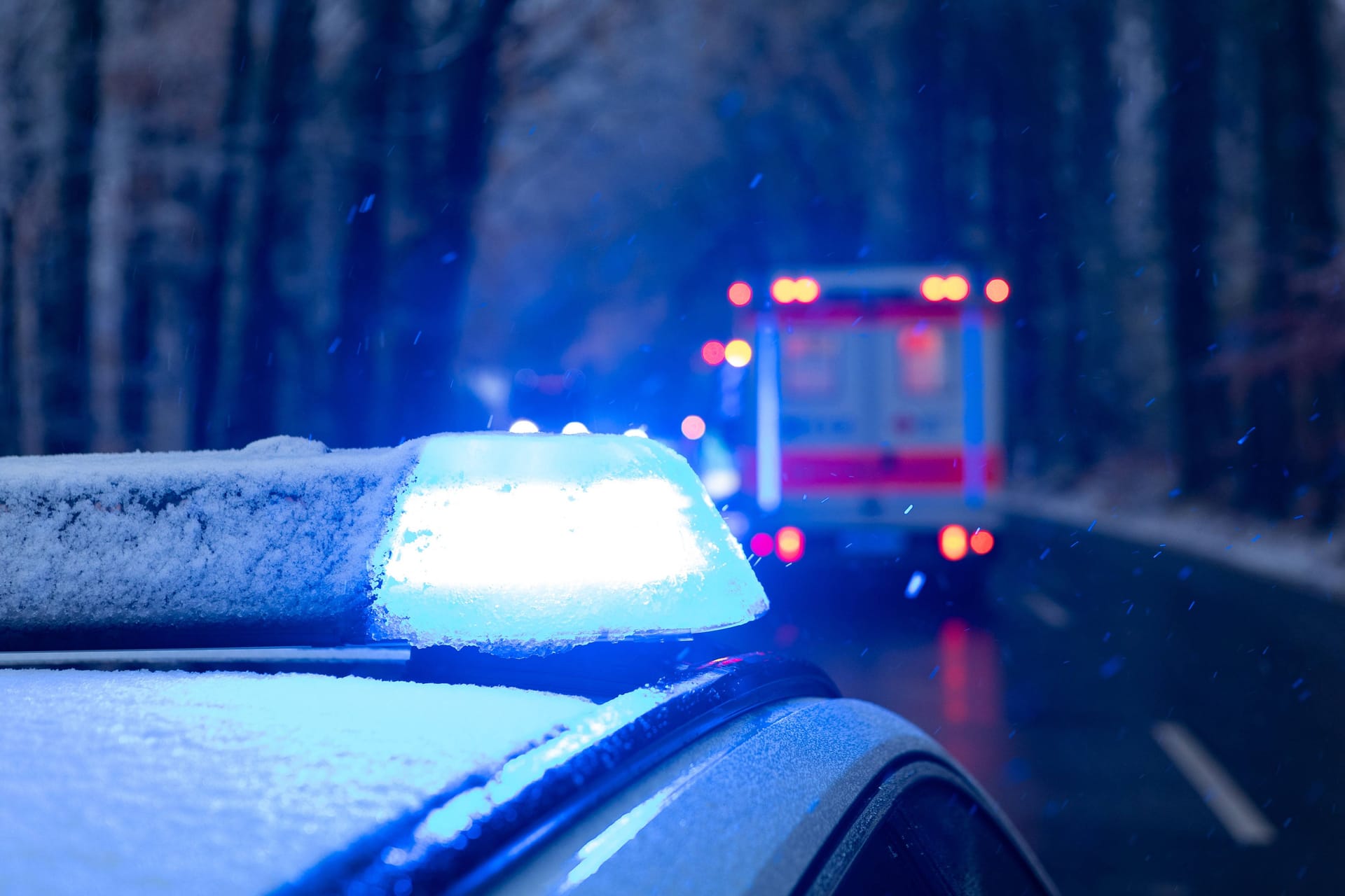 Streifenwagen der Polizei mit Blaulicht bei Schneefall (Symbolbild): Lebensgefahr besteht laut Polizei bei den Verletzten nicht.