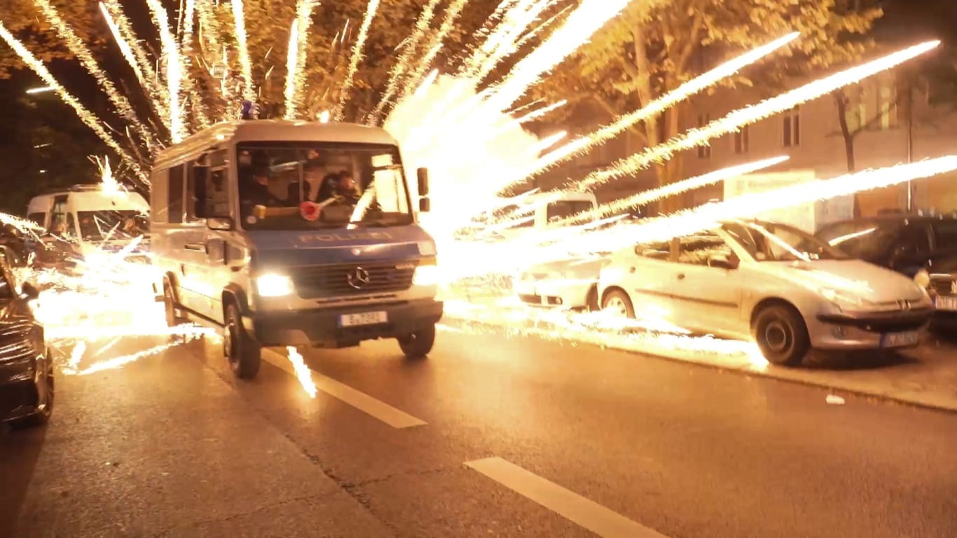 Feuerwerkskörper explodieren hinter einem Polizeiauto (Archivbild): Bei einer nicht angekündigten pro-palästinensischen Demonstration in Neukölln kam es am 18. Oktober zu massiven Ausschreitungen.