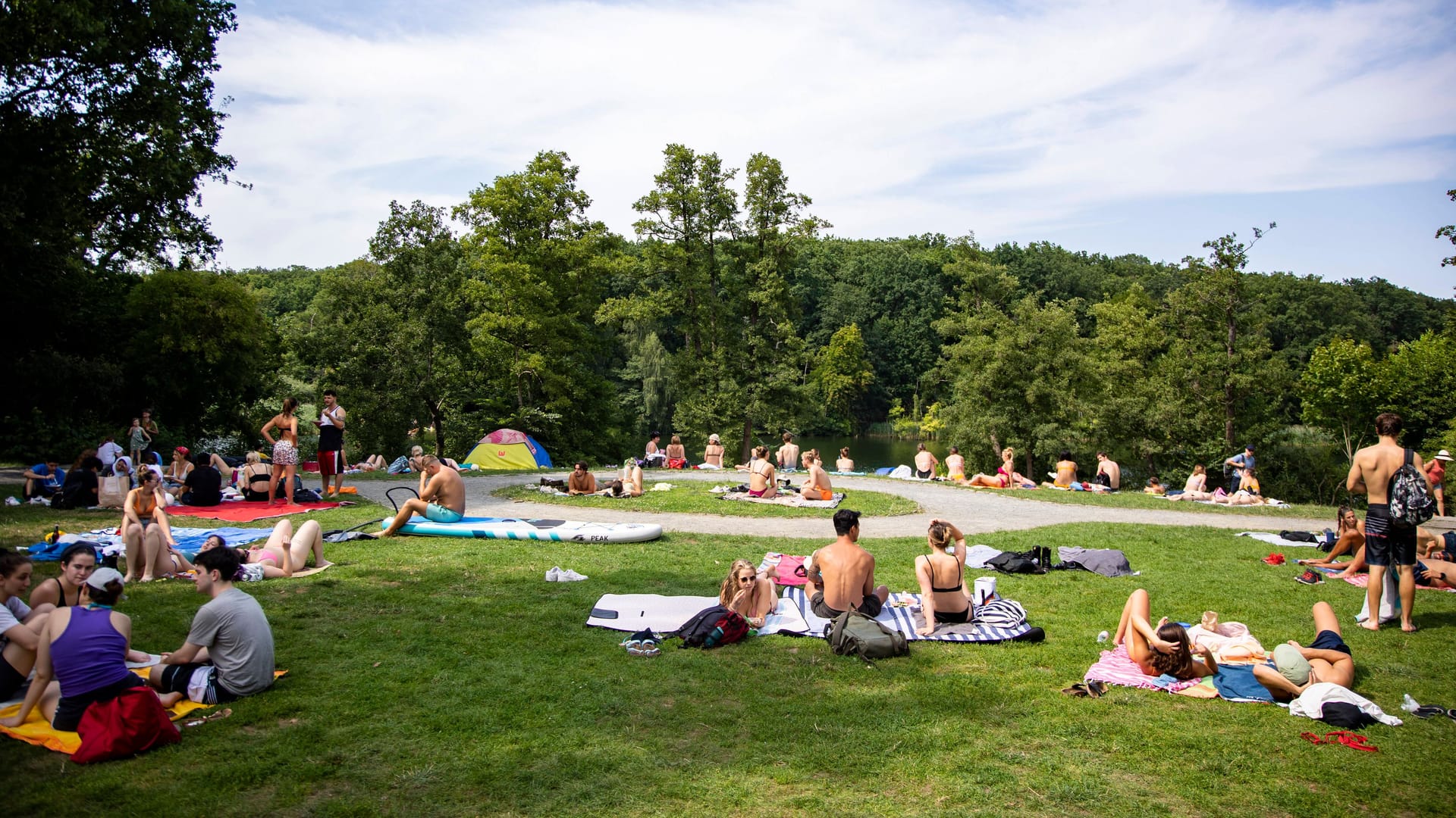 Menschen auf der Wiese und im Wasser am Schlachtensee in Berlin