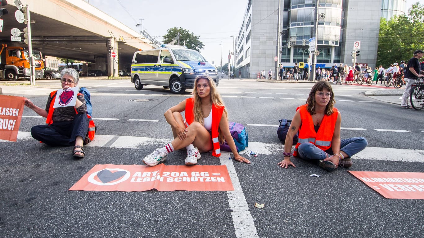 Aktivisten der "Letzten Generation" bei einer Straßenblockade im Sommer in München (Archivbild).
