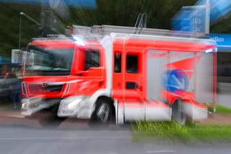 Ein Feuerwehrauto auf Einsatzfahrt (Symbolbild): Mit Drehleitern retteten die Einsatzkräfte die Bewohner vom Dach und aus den Wohnungen.